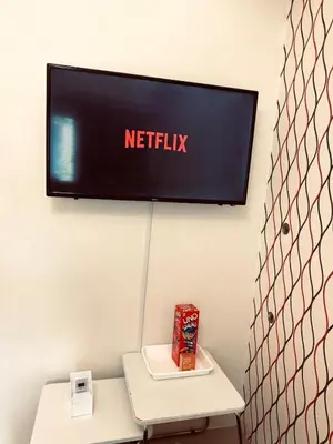 a tv on the wall with a netflix sign on it at High Rise Haven in Makati with Balcony and View in Manila