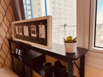 a small table with a plant on a window sill at High Rise Haven in Makati with Balcony and View in Manila
