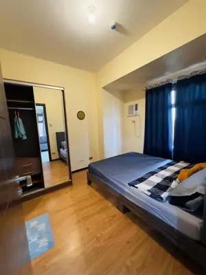 a bedroom with a bed and a large mirror at 1 BEDROOM Staycation in Manila