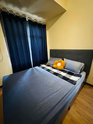 a teddy bear laying on a bed in a bedroom at 1 BEDROOM Staycation in Manila