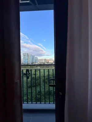 a room with a view of a city from a balcony at Hearth of Ember 2 at Shore 3 Residences in Manila