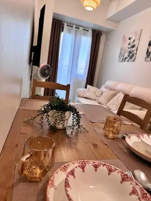 a dining room table with plates and glasses on it at Hearth of Ember 2 at Shore 3 Residences in Manila