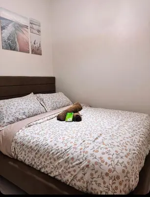 a bed with a stuffed animal laying on it at Hearth of Ember 2 at Shore 3 Residences in Manila