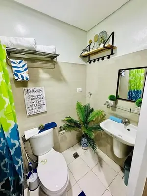 a bathroom with a toilet and a sink at Niereys Suite 1071 in Manila