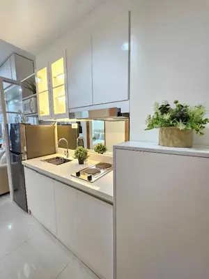 a kitchen with white cabinets and plants on the counter at Shore 3 Tower 4 Amenity View Pasay in Manila