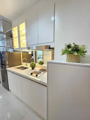 a kitchen with white cabinets and plants on the counter at Shore 3 Tower 4 Amenity View Pasay in Manila