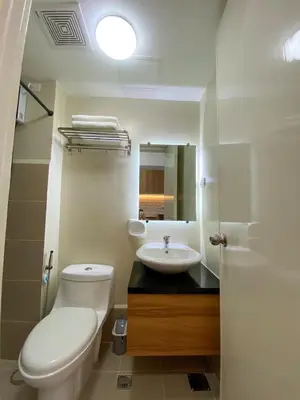 a bathroom with a white toilet and a sink at cozy studio unit near airport in Manila