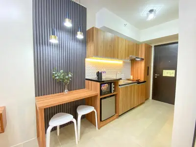 a kitchen with a counter and two stools in it at cozy studio unit near airport in Manila