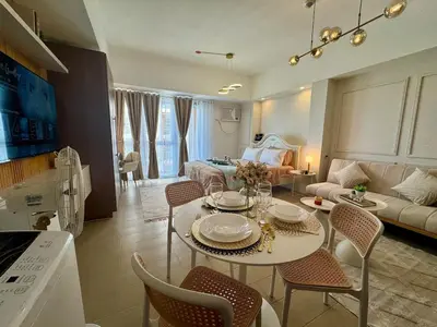 a kitchen and living room with a table and chairs at Chic Staycation with Balcony,few step in venice mall in Manila