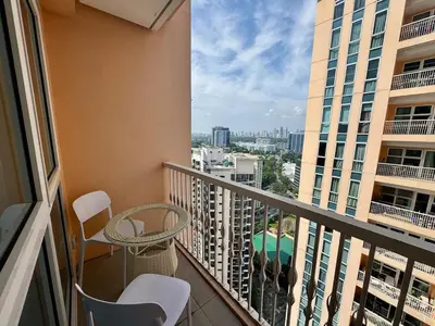 a balcony with a table and chairs and a view of a city at Chic Staycation with Balcony,few step in venice mall in Manila