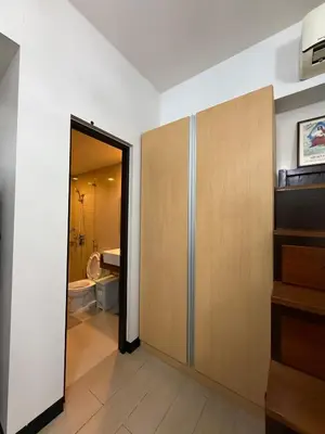 a bathroom with a door leading to a toilet at Luxurious Studio Unit in Salcedo in Manila