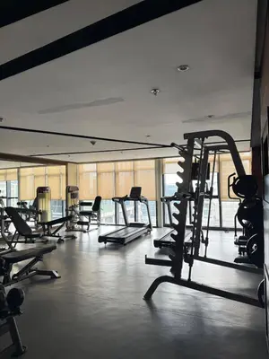 a gym with several treadmills and elliptical machines at Luxurious Studio Unit in Salcedo in Manila