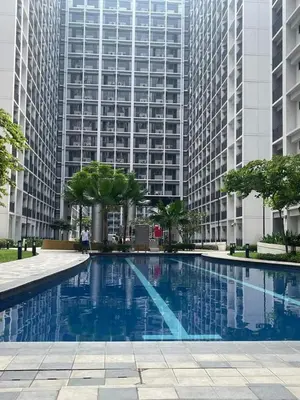 a swimming pool in front of a tall building at Shore Residence 1 Bedroom Staycation in Manila