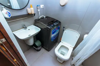 a small bathroom with a toilet and a sink at Chic Floating Penthouse Makati Gym Air condo gym swim park 300MB in Manila