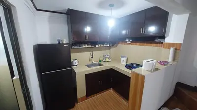 a small kitchen with black cabinets and a black refrigerator at Affordable Whole house 2-story 3 bedroom Greenpark villas imus phase 1 in Imus