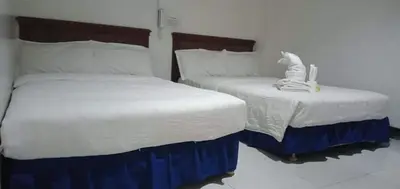 two twin beds in a bedroom with a statue of a cat on top at Asia Novo Boutique Hotel - Cabuyao Laguna in Cabuyao