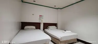 two beds in a room with white walls at Asia Novo Boutique Hotel - Cabuyao Laguna in Cabuyao