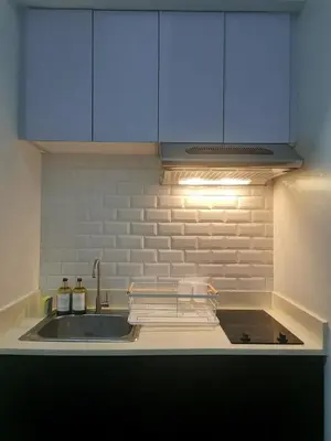 a kitchen with a sink and blue cabinets at Studio condo near Pobla Makati in Manila