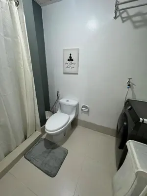 a bathroom with a toilet and a picture on the wall at Studio condo near Pobla Makati in Manila