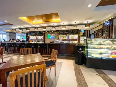 a restaurant with a bar with tables and a counter at Studio condo near Pobla Makati in Manila