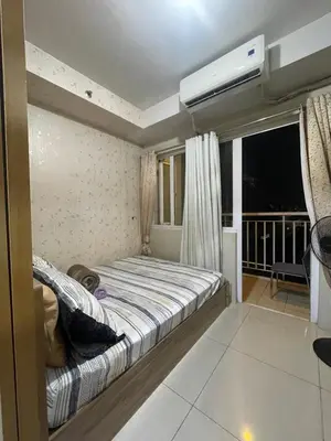 a bedroom with a bed and a air conditioner at Shell residence moa in Manila