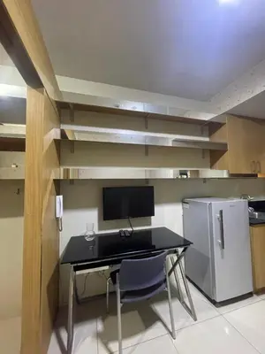 a kitchen with a black desk and a refrigerator at Shell residence moa in Manila