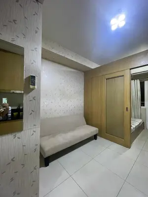 a room with a bench in the corner of a room at Shell residence moa in Manila