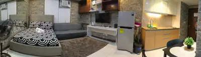 a kitchen with a couch and a refrigerator in a room at Nethcondo in Manila