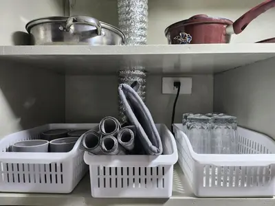 a kitchen shelf with two white baskets and dishes at TheMudroomStyle ideal WFH near St Benedict Parish in Silang