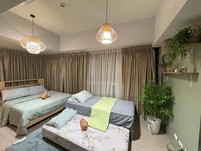 a bedroom with two beds and two potted plants at Cozy 3 Bedroom in Uptown Parksuites - Near Mall, Restaurants and Supermarket in Manila