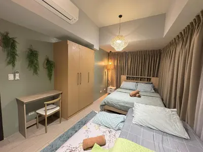 a bedroom with two beds and a desk and a desk at Cozy 3 Bedroom in Uptown Parksuites - Near Mall, Restaurants and Supermarket in Manila