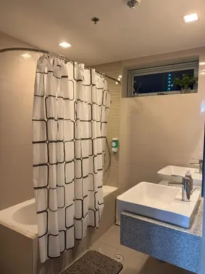 a bathroom with a sink and a shower curtain at Cozy 3 Bedroom in Uptown Parksuites - Near Mall, Restaurants and Supermarket in Manila