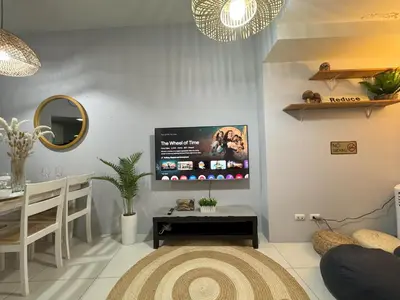 a living room with a flat screen tv on the wall at Cozy 3 Bedroom in Uptown Parksuites - Near Mall, Restaurants and Supermarket in Manila