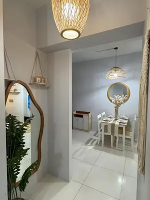 a dining room with a table and a chandelier at Cozy 3 Bedroom in Uptown Parksuites - Near Mall, Restaurants and Supermarket in Manila