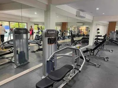 a gym with cardio equipment and people in the background at Filed Residences Hotel Apartment in Manila