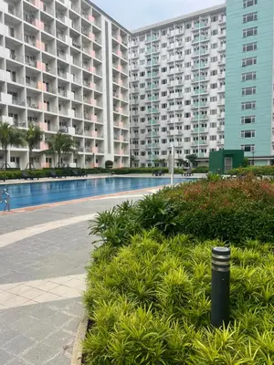 a large apartment complex with a swimming pool and buildings at Filed Residences Hotel Apartment in Manila