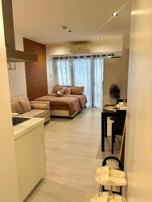 a bedroom with a bed and a couch and a table at ElixirStaycation at Knightsbridge Residences in Manila
