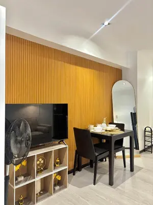 a dining room with a table and a yellow wall at ElixirStaycation at Knightsbridge Residences in Manila