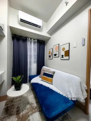 a bedroom with a blue bed and a window at Luxurious Condo Near SM MOA in Manila