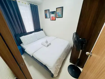 a small bedroom with a bed and a window at Luxurious Condo Near SM MOA in Manila