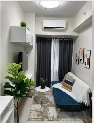 a living room with a blue couch and a window at Luxurious Condo Near SM MOA in Manila