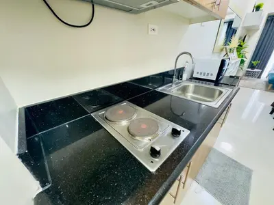 a kitchen with a stove and a sink in it at Luxurious Condo Near SM MOA in Manila