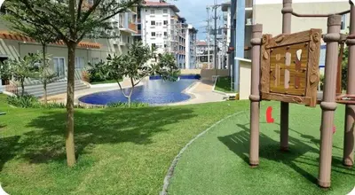 a park with a sign in the grass next to a building at Joms Minimalist Crib Nuvali in Calamba