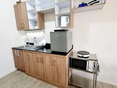 a kitchen with a sink and a microwave at Joms Minimalist Crib Nuvali in Calamba