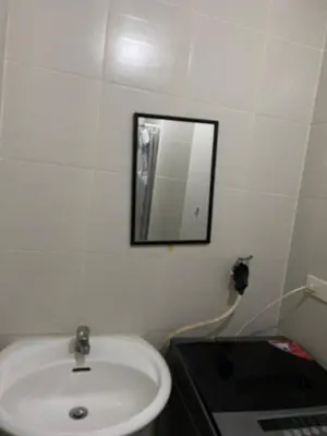 a bathroom with a sink and a mirror on the wall at jazz residence in Manila