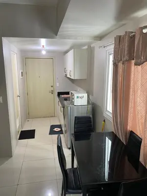 a small kitchen with a table and a dining room at jazz residence in Manila