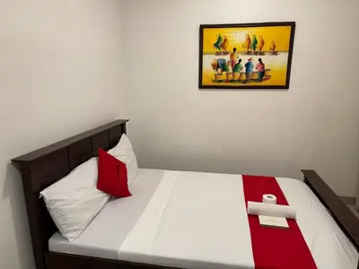 a bed in a room with a picture on the wall at Casa Maria by Juemarst Suites in Manila