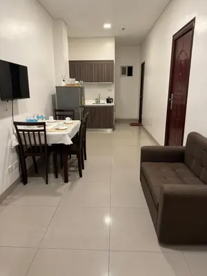 a living room and kitchen with a table and a couch at Casa Maria by Juemarst Suites in Manila