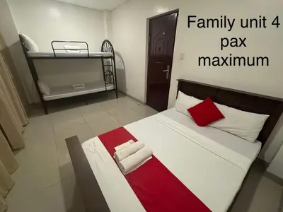 a bedroom with a large bed with red and white pillows at Casa Maria by Juemarst Suites in Manila