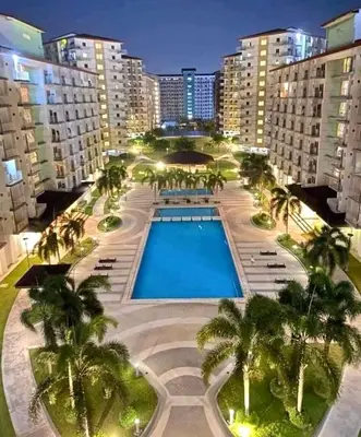 an overhead view of a resort with a pool and palm trees at Field Residences Condo Hotel in Manila